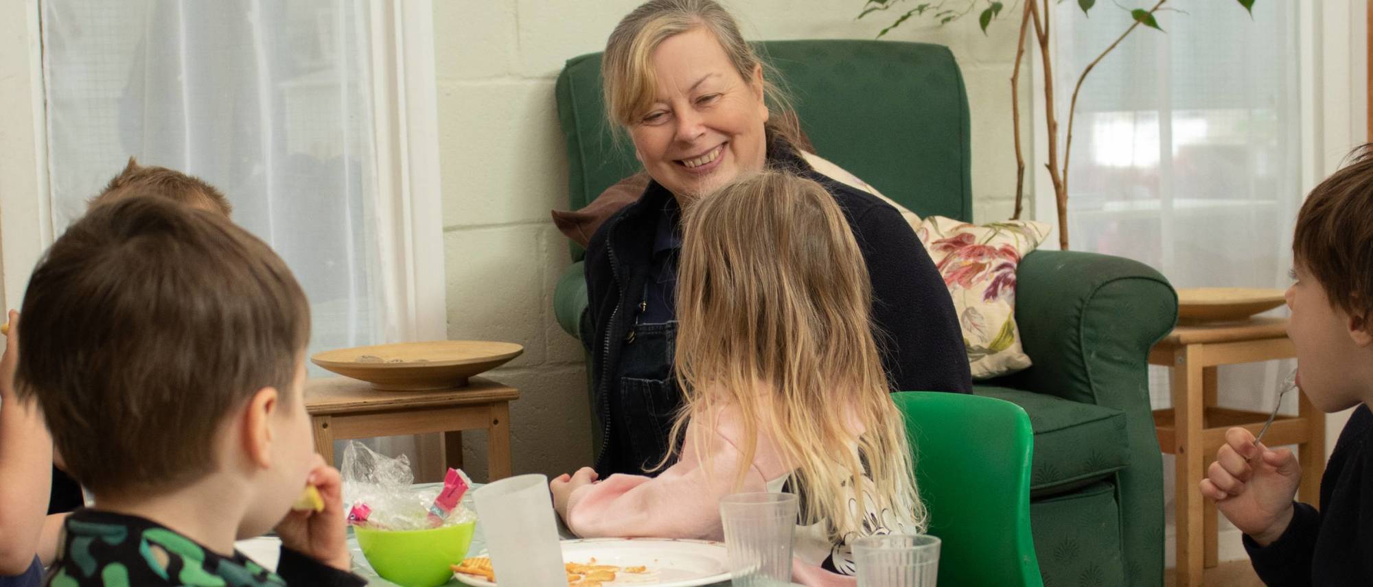 staff-and-children-smiling-while-eating-lunch